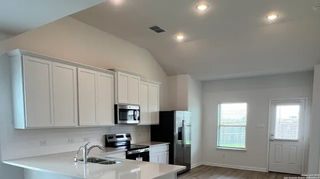 a kitchen with stainless steel appliances a stove a sink a refrigerator and cabinets