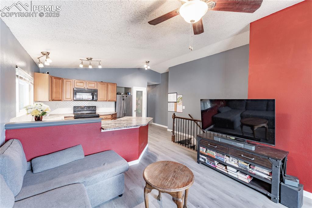 538 Blossom Field Road Fountain, CO 80817 - Photo 3 of 16 a living room with furniture a flat screen tv and kitchen view