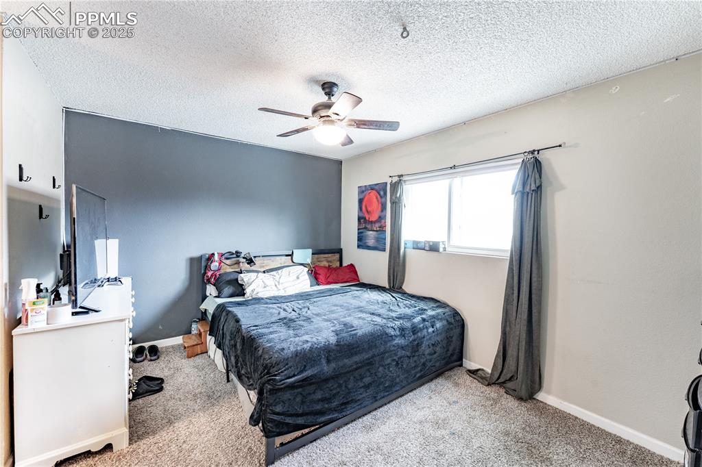 538 Blossom Field Road Fountain, CO 80817 - Photo 5 of 16 a bedroom with a bed and a chandelier