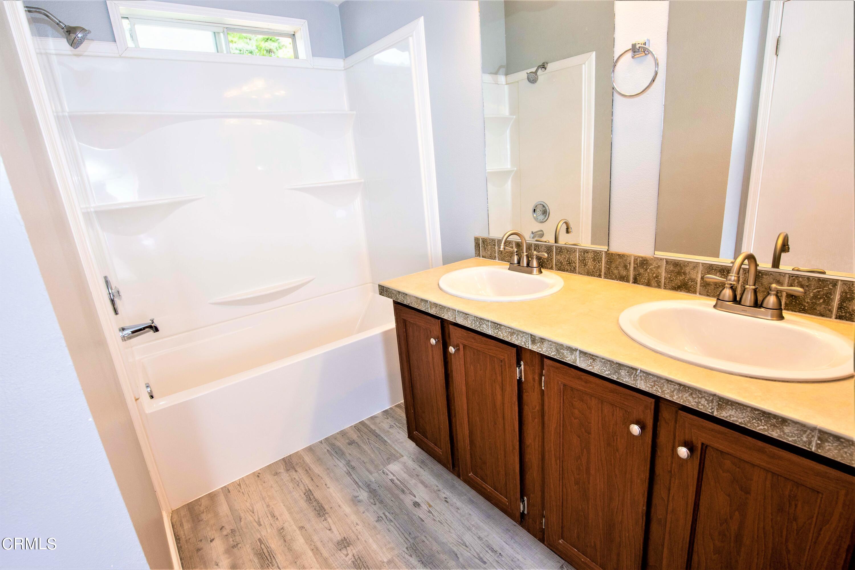 3536 East Guiberson Road Fillmore, CA 93015 - Photo 54 of 64 a bathroom with a granite countertop sink a mirror a vanity and a bathtub
