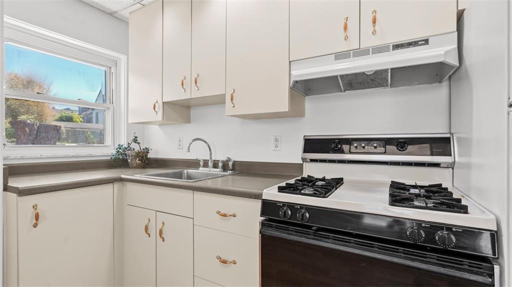 210 19th Street Pittsburgh, PA 15215 - Photo 12 of 33 a kitchen with white cabinets and appliances