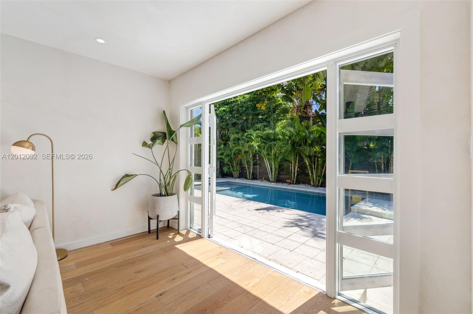 830 Northeast 72nd Street Miami, FL 33138 - Photo 10 of 19 a view of a living room and a large window wooden floor