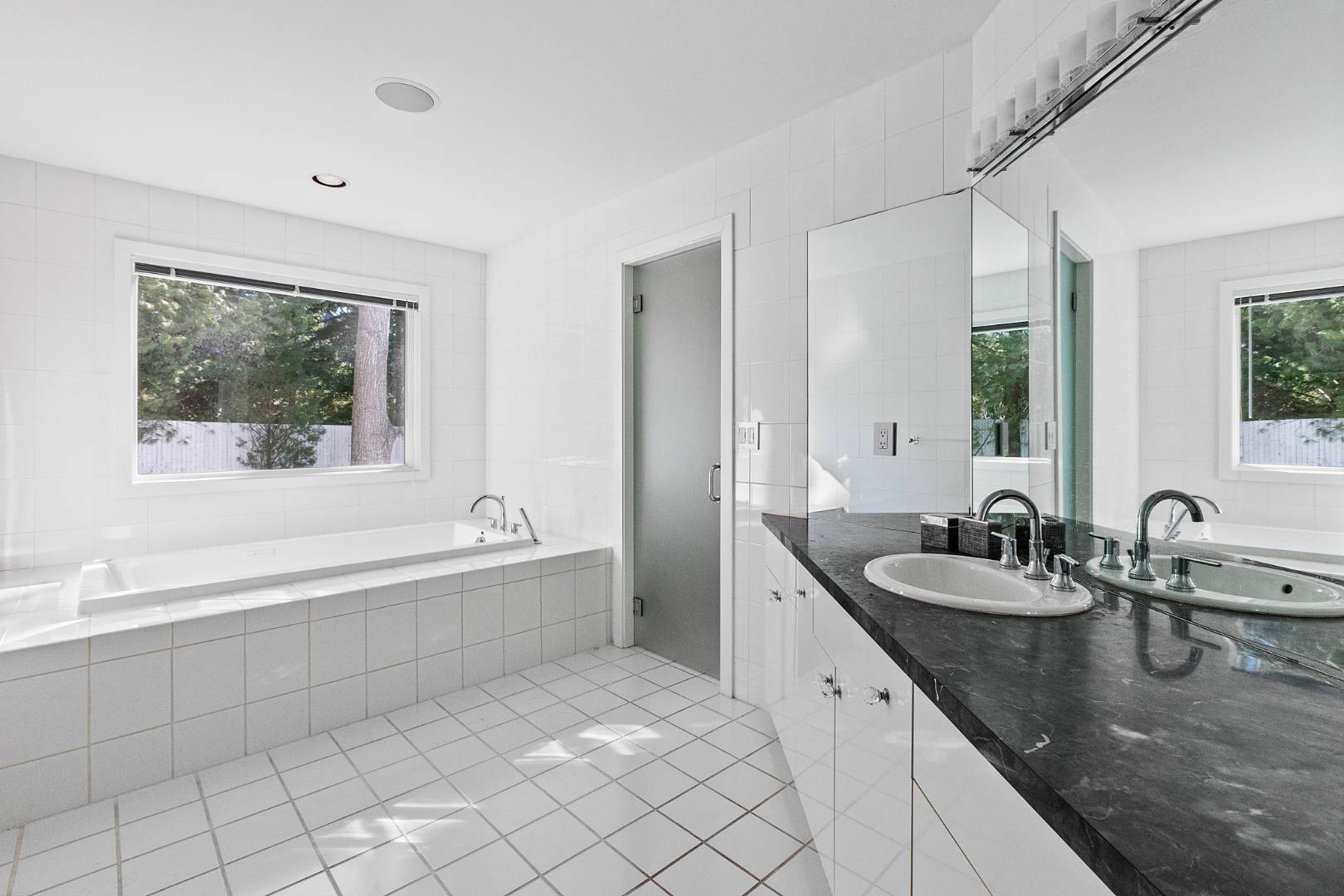 47 Tansey Lane Bridgehampton, NY 11932 - Photo 16 of 28 a bathroom with a granite countertop sink and mirror with bathtub