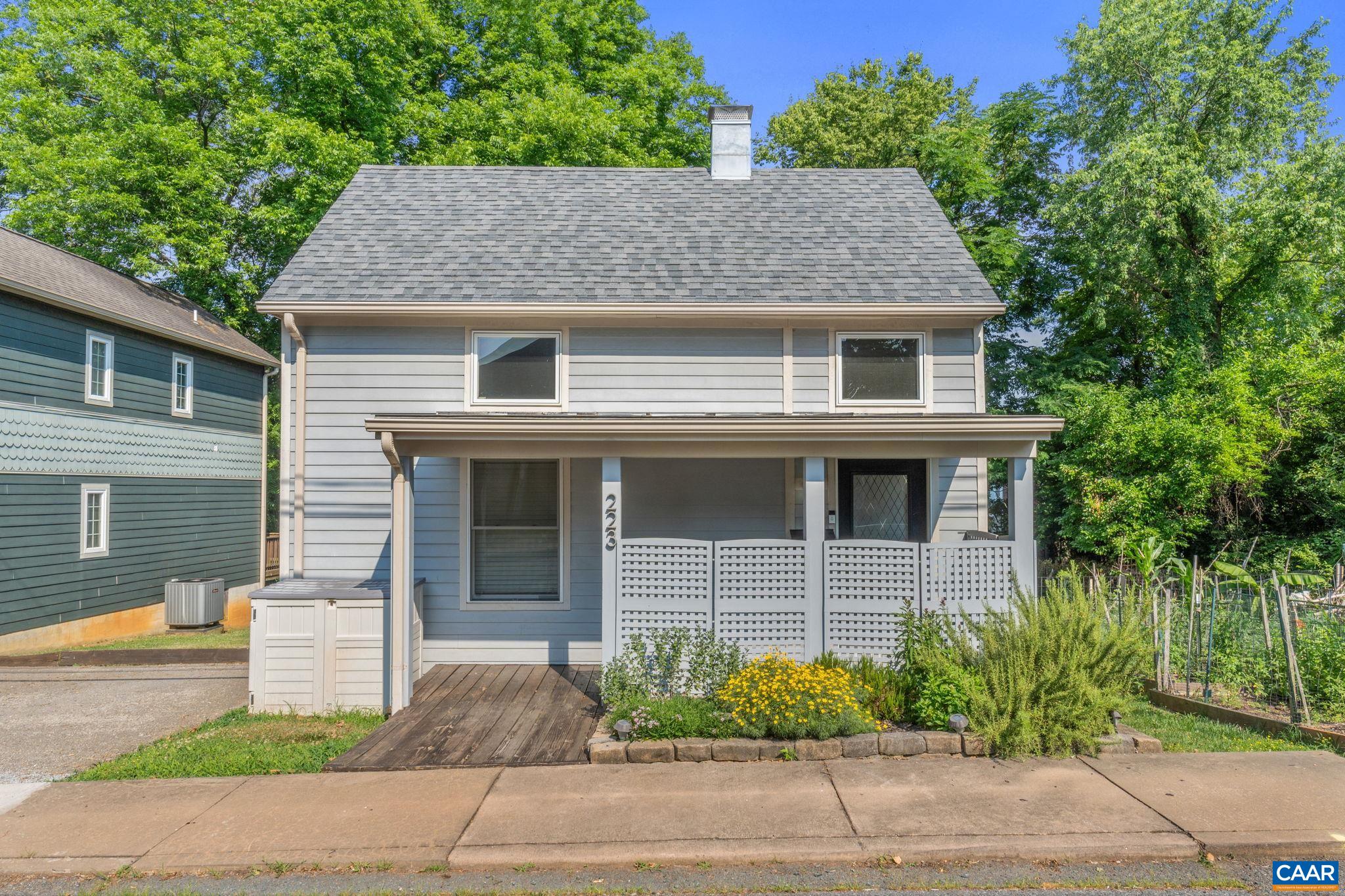 a front view of a house with a garden and plants