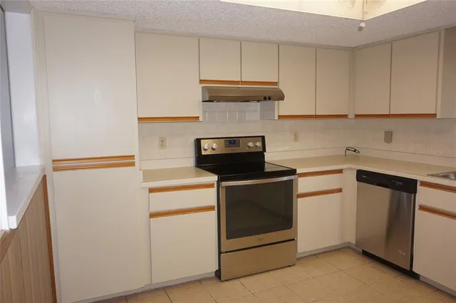 a kitchen with white cabinets and white appliances