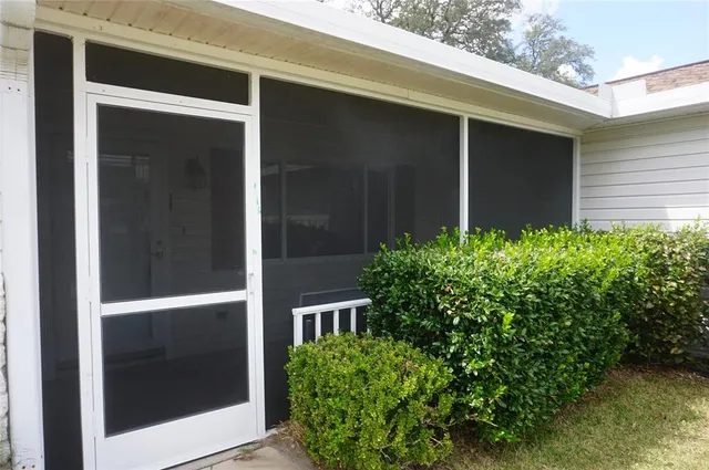 a view of backyard with potted plant front of door