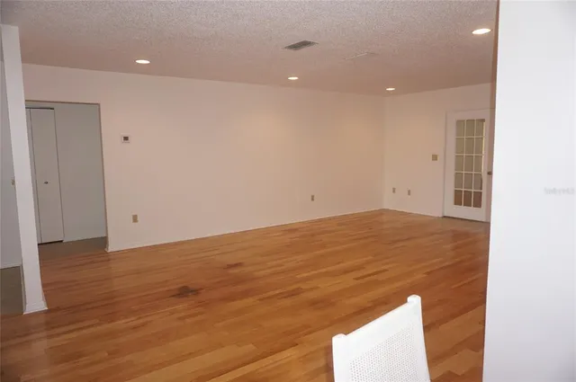 an empty room with wooden floor and cabinet