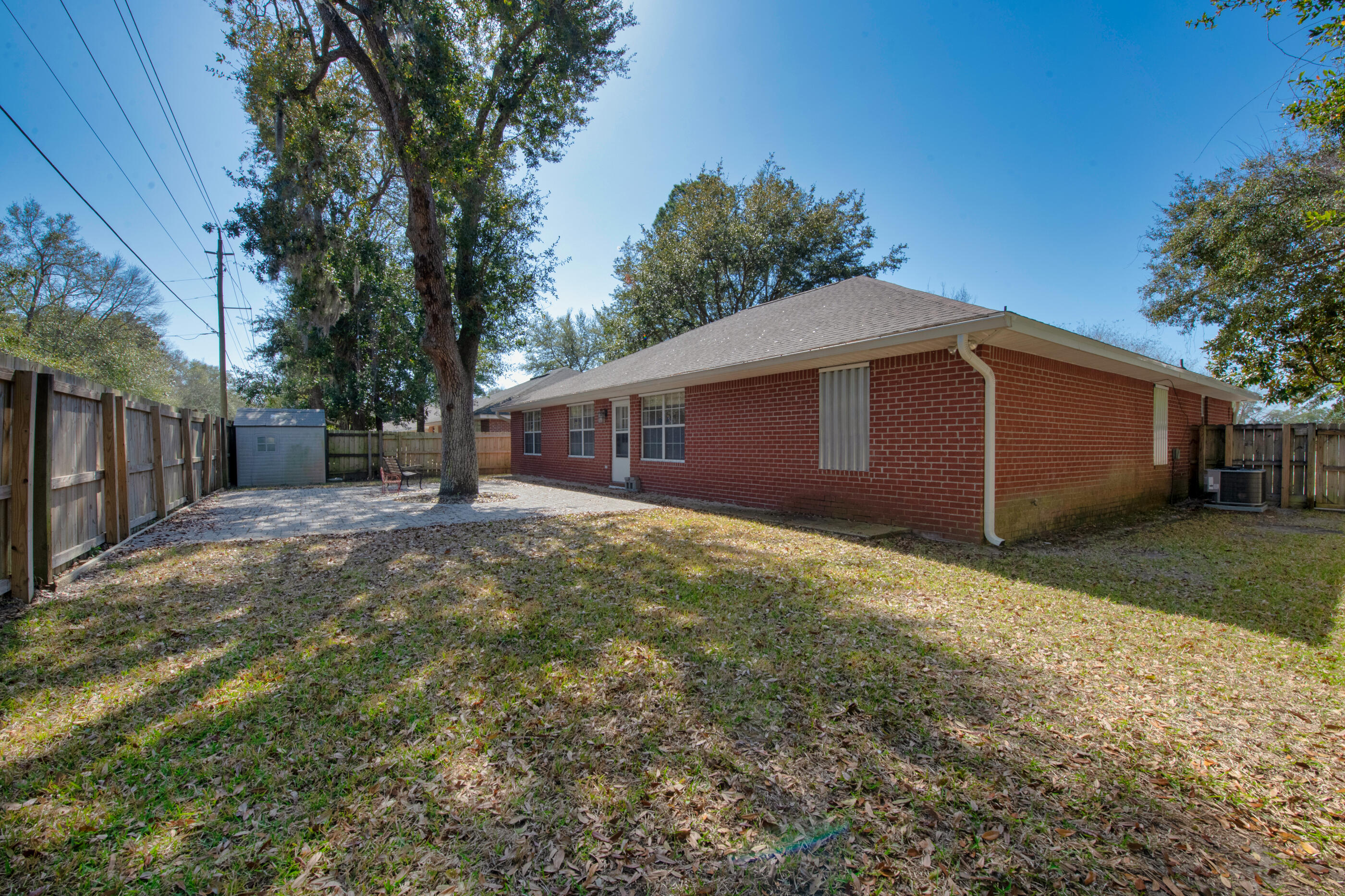 44 Beacon Way Santa Rosa Beach, FL 32459 - Photo 2 of 29 a backyard of a house with large trees and wooden fence
