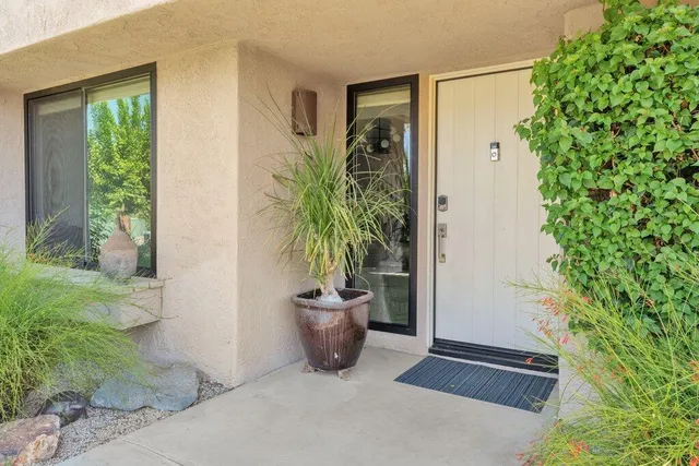 a view of a patio with couches table and chairs under an umbrella