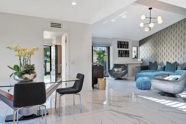 a view of a patio with couches table and chairs under an umbrella