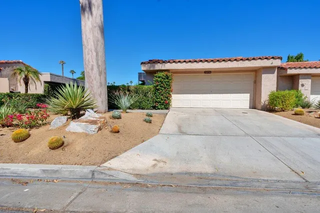 a living room with furniture a chandelier a large window and a flat screen tv