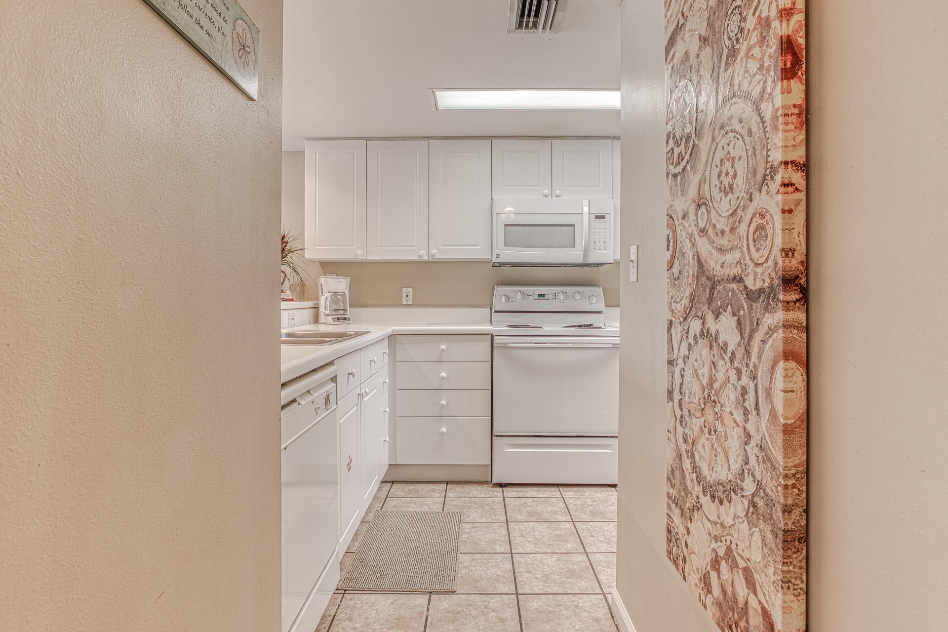 895 Santa Rosa Boulevard, Unit 214 Fort Walton Beach, FL 32548 - Photo 3 of 37 a kitchen with a stove a sink and a refrigerator