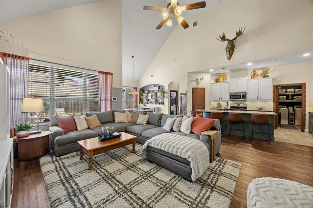 a living room with furniture kitchen view and a large window