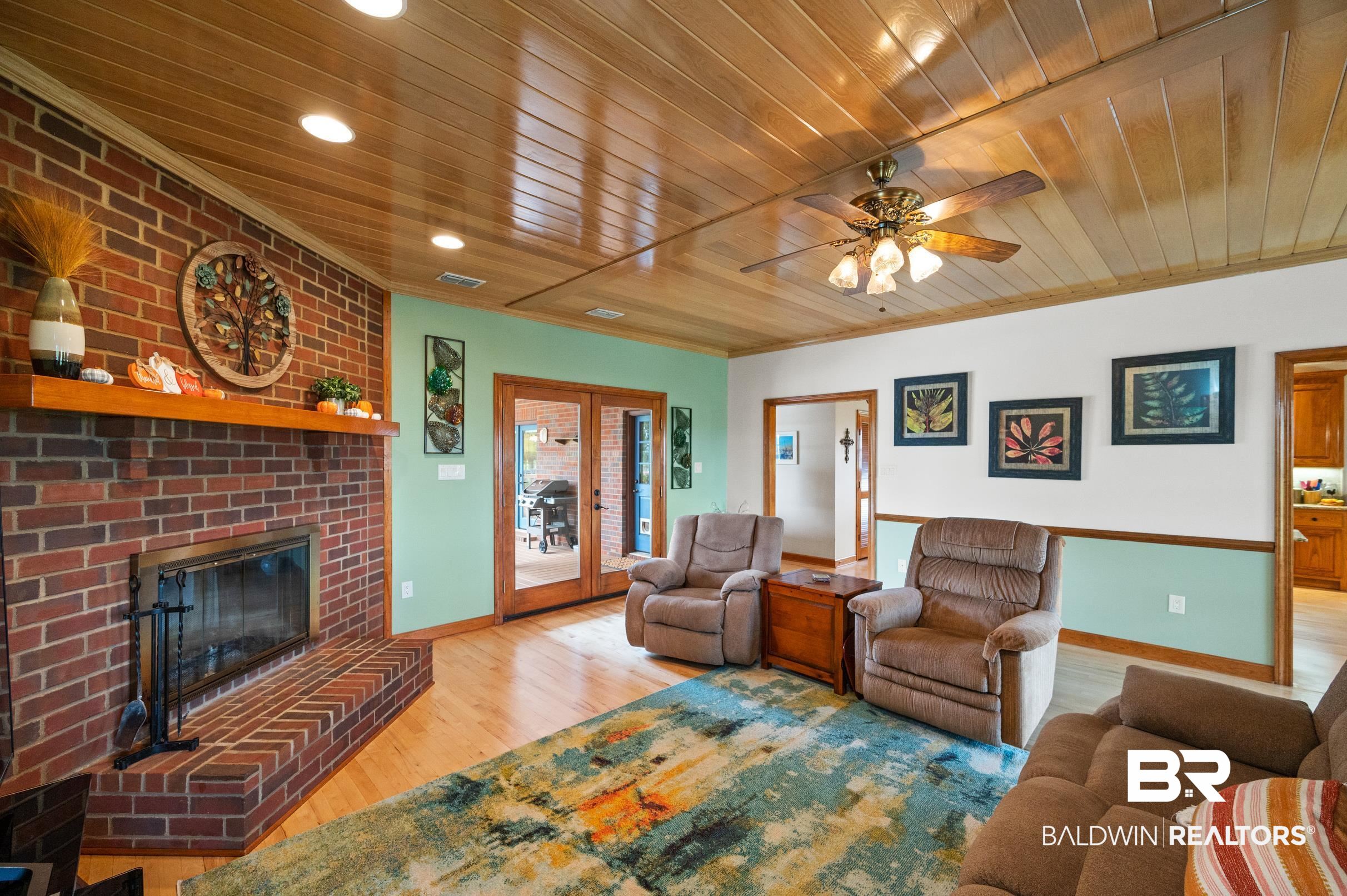 13871 Underwood Road Summerdale, AL 36580 - Photo 3 of 33 Living room featuring ceiling fan, Maple Hardwood Floors, Ash Wood Ceiling, and a Brick Woodburning Fireplace