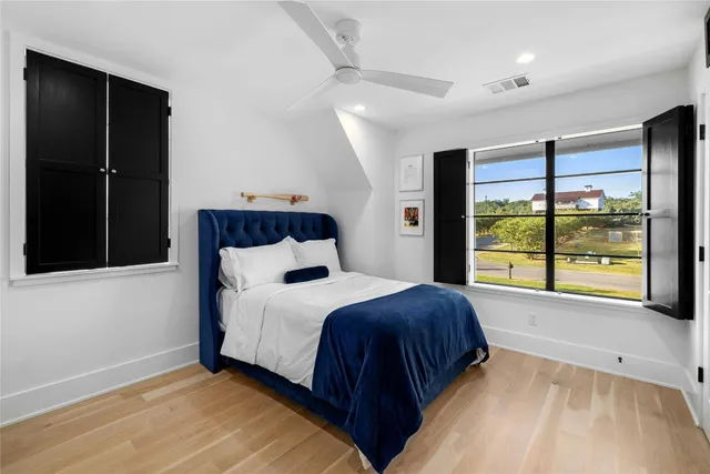 a bedroom with a large bed and a chandelier