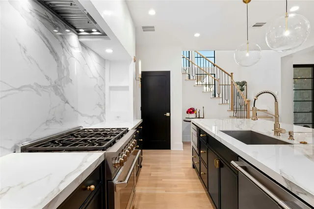 a kitchen with stainless steel appliances granite countertop a sink stove and refrigerator