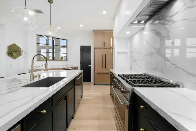 a kitchen with granite countertop a sink stove and cabinets