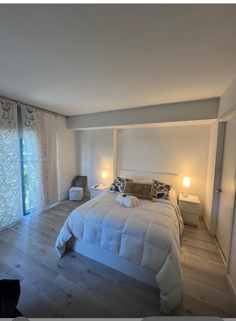 31 Southeast 6th Street, Unit 804 Miami, FL 33131 - Photo 5 of 13 a bedroom with a bed and a mirror