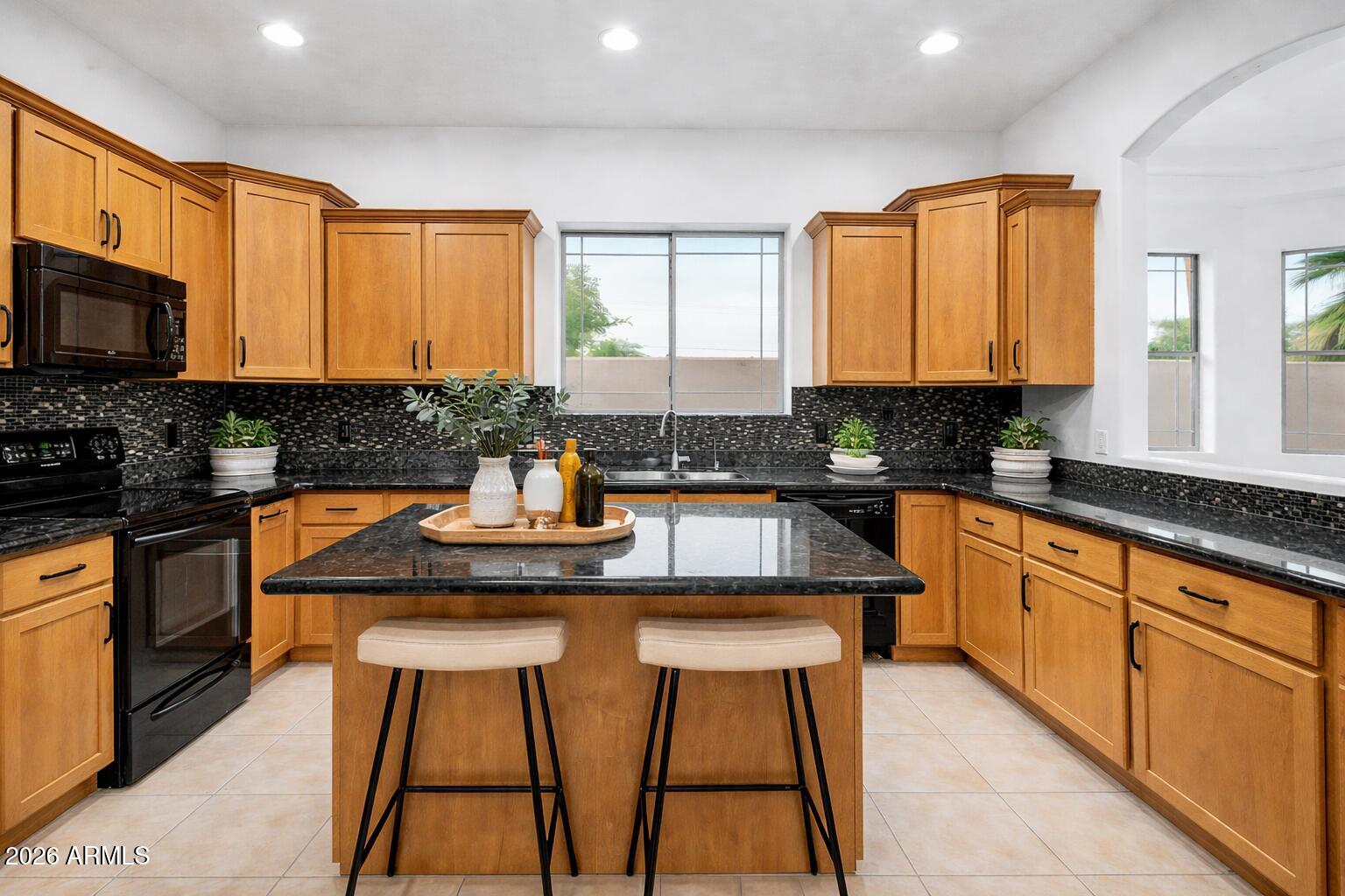 6202 East McKellips Road, Unit 19 Mesa, AZ 85215 - Photo 11 of 37 a kitchen with stainless steel appliances granite countertop a sink stove and cabinets
