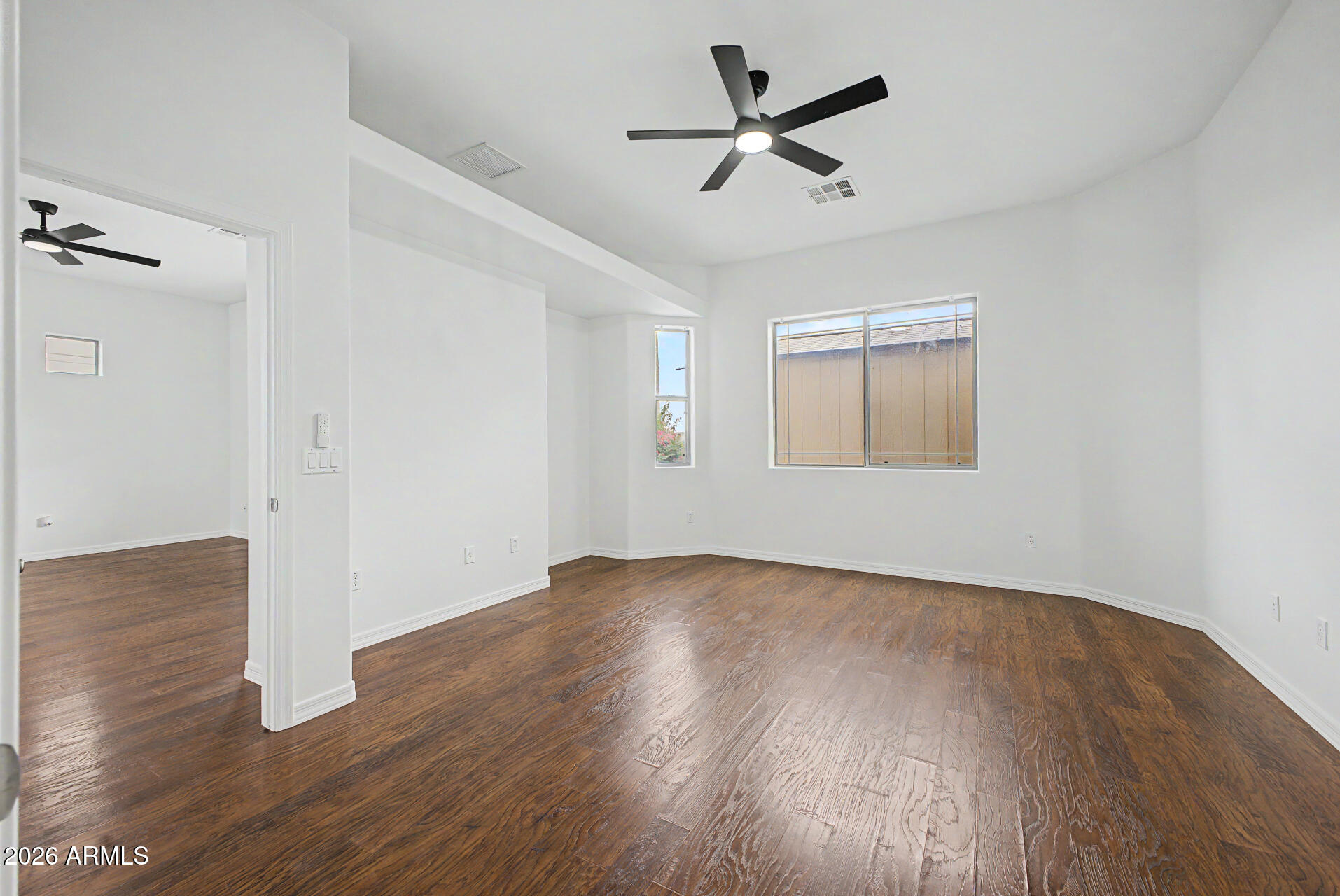 6202 East McKellips Road, Unit 19 Mesa, AZ 85215 - Photo 19 of 37 an empty room with wooden floor ceiling fan and windows