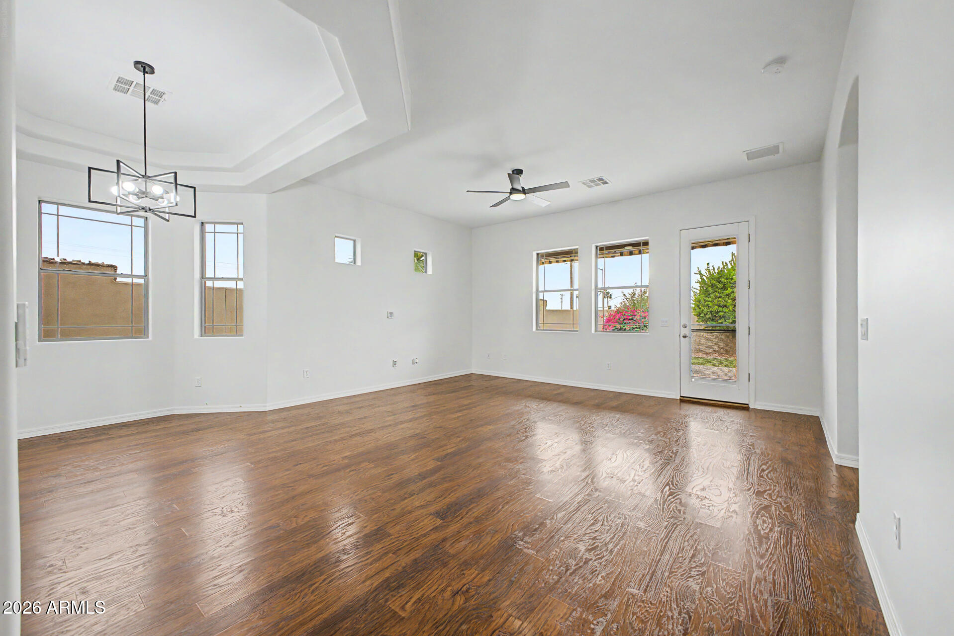 6202 East McKellips Road, Unit 19 Mesa, AZ 85215 - Photo 7 of 37 a view of an empty room with window and wooden floor