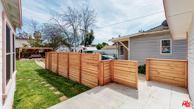 a view of a patio with couches table and chairs and potted plants