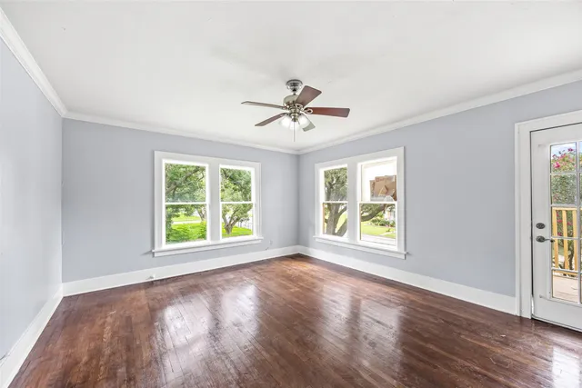 a view of an empty room with a window and wooden floor