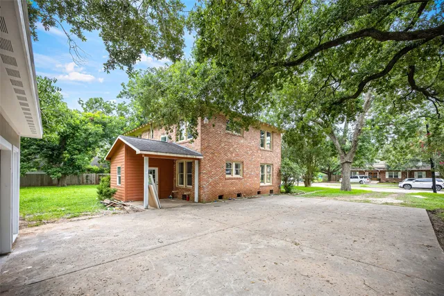 a view of a house with backyard and trees