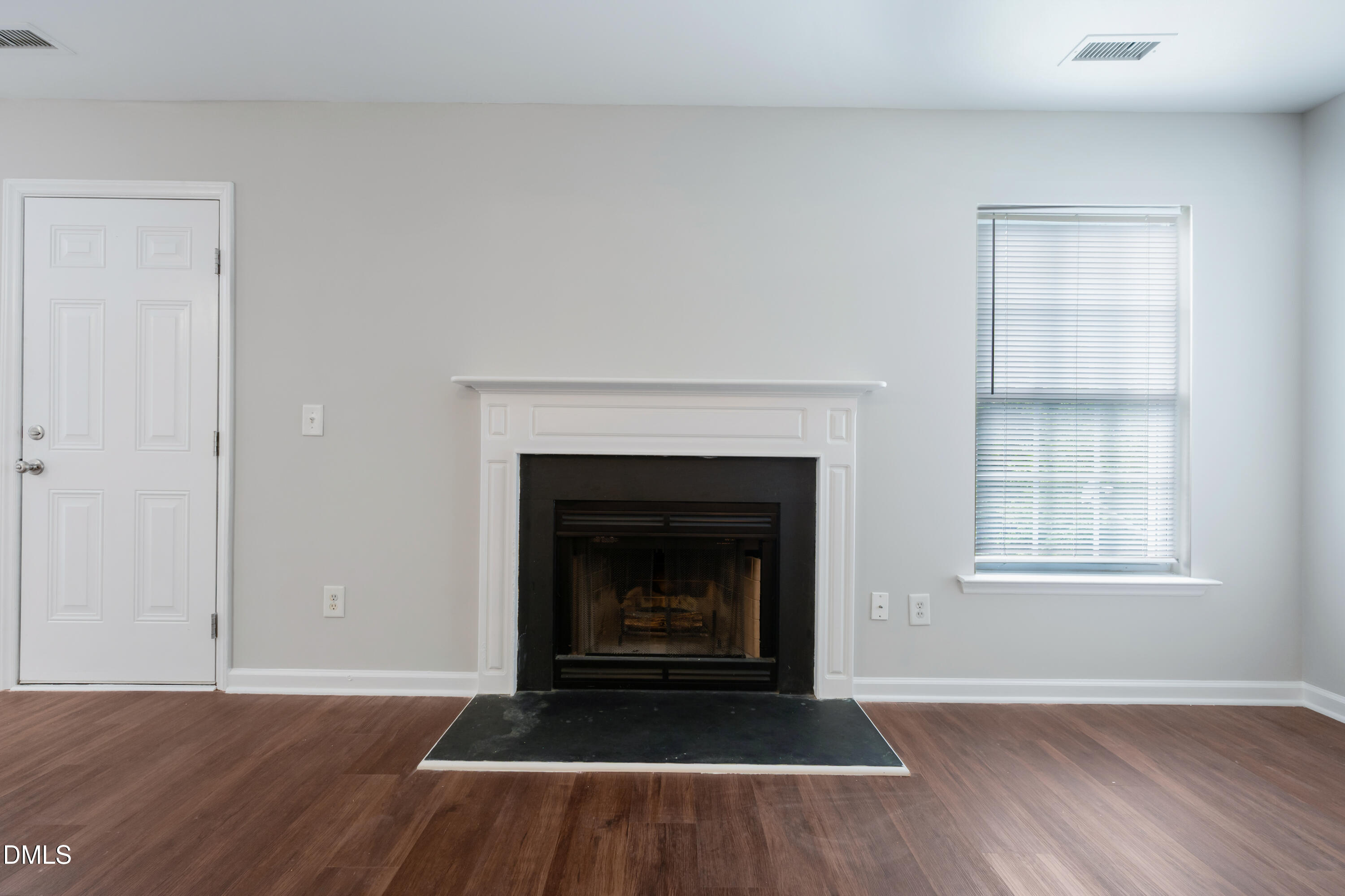 1532 Pebble Ridge Drive Raleigh, NC 27610 - Photo 9 of 40 a view of an empty room with wooden floor fireplace and a window