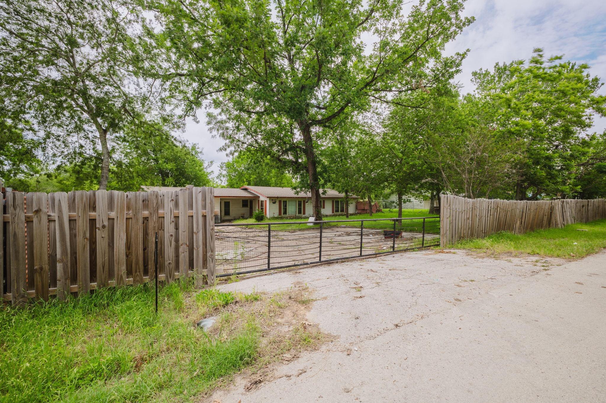 6803 Viewing Place Austin, TX 78719 - Photo 2 of 20 A private, fenced property offers a serene retreat amidst mature trees.