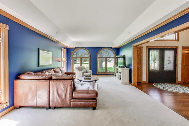 a dining room with wooden floor a chandelier a wooden table and chairs