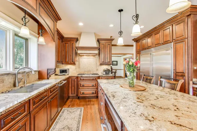 a kitchen with stainless steel appliances granite countertop a sink a stove and a refrigerator