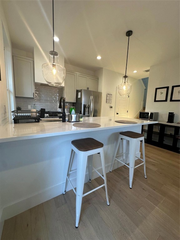 3417 Elija Street, Unit 2 Austin, TX 78745 - Photo 4 of 28 Kitchen with hanging light fixtures, a peninsula, stainless steel appliances, light wood-type flooring, and recessed lighting