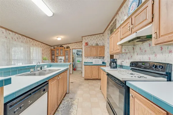a kitchen with a sink stove top oven and cabinets