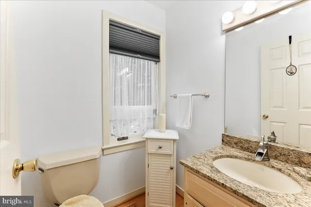 a large white kitchen with stainless steel appliances granite countertop a stove and a sink