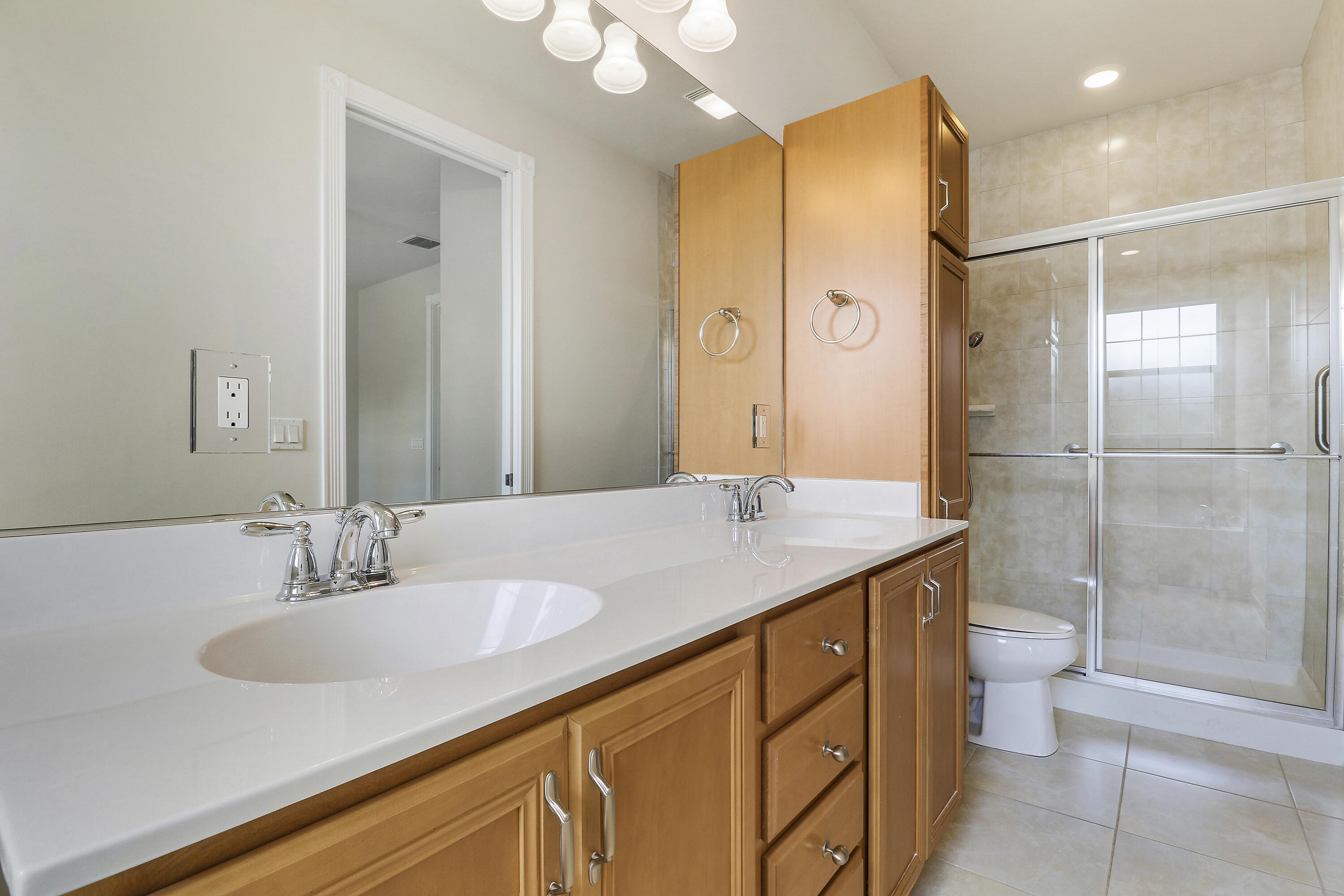 1043 Key Largo Street Jupiter, FL 33458 - Photo 22 of 46 a bathroom with a granite countertop sink a toilet a mirror and shower