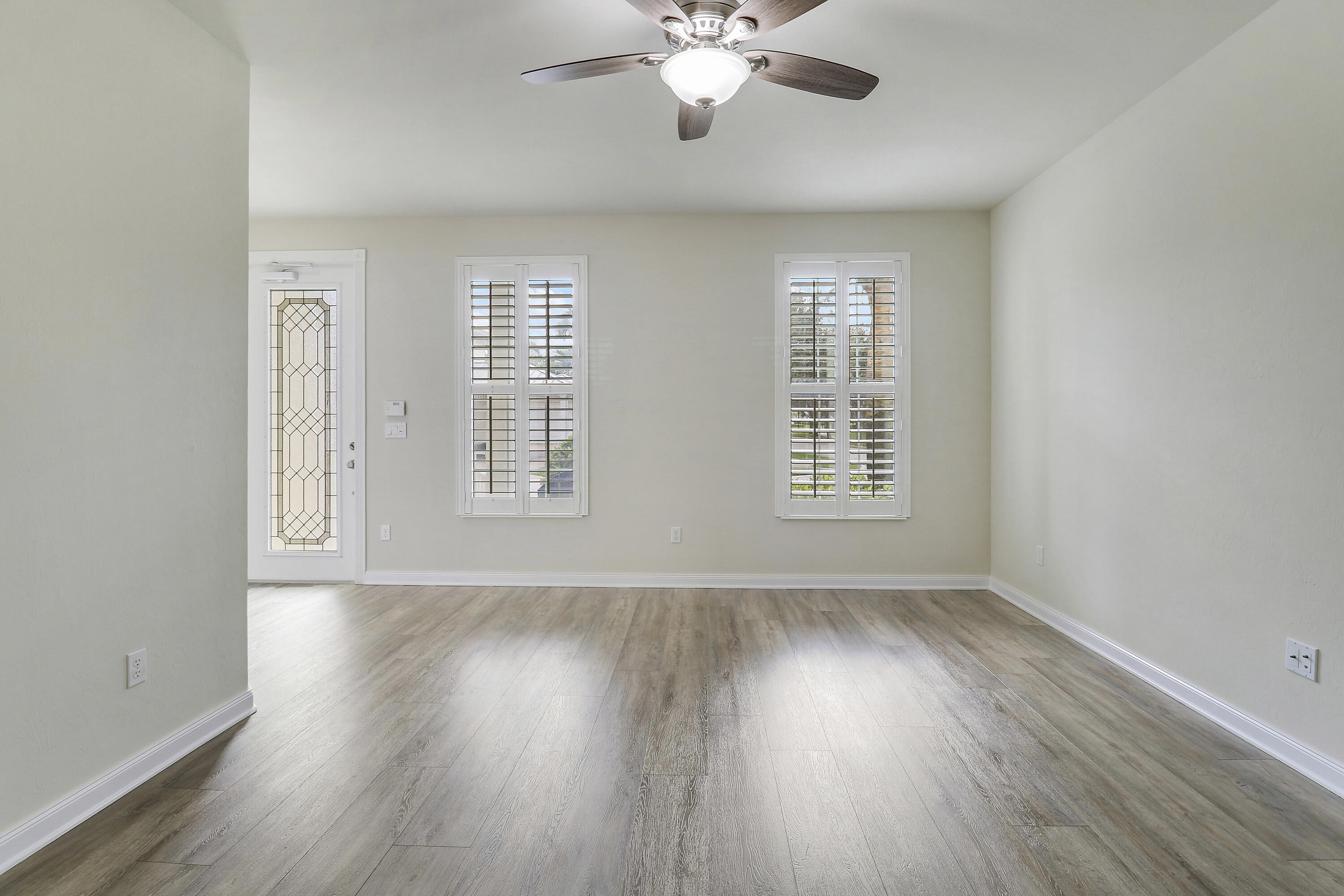 1043 Key Largo Street Jupiter, FL 33458 - Photo 6 of 46 a view of an empty room with wooden floor and a window