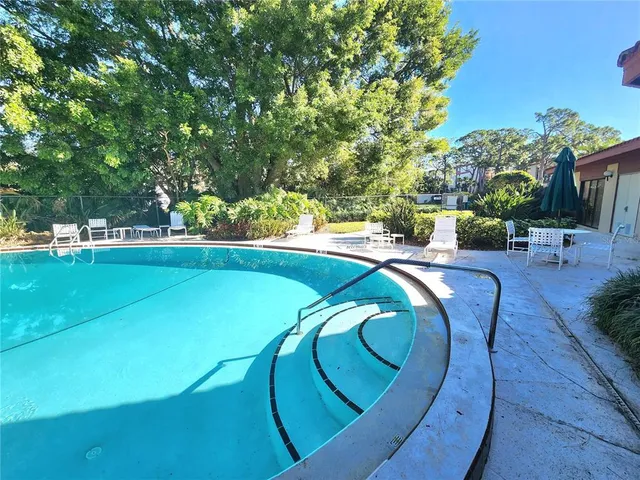 a view of a swimming pool with outdoor seating and plants