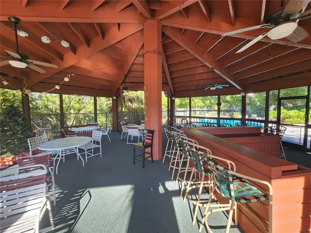a view of a patio with table and chairs under an umbrella with a barbeque grill