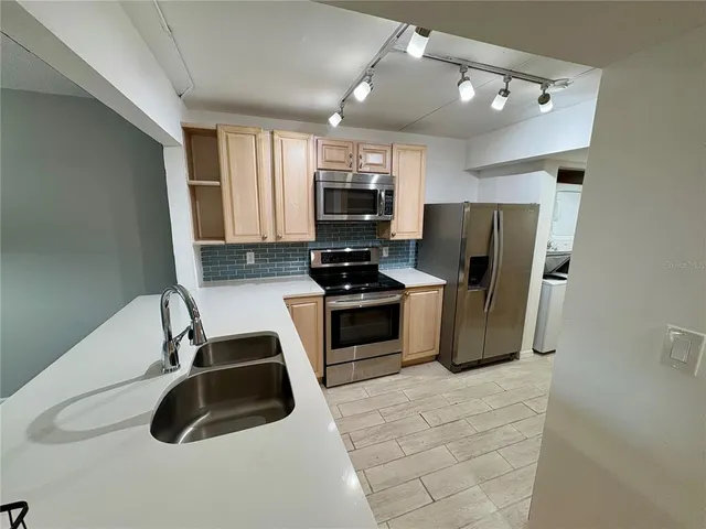 a kitchen with stainless steel appliances a refrigerator and a stove top oven