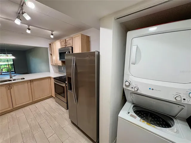 a kitchen with a refrigerator sink and cabinets