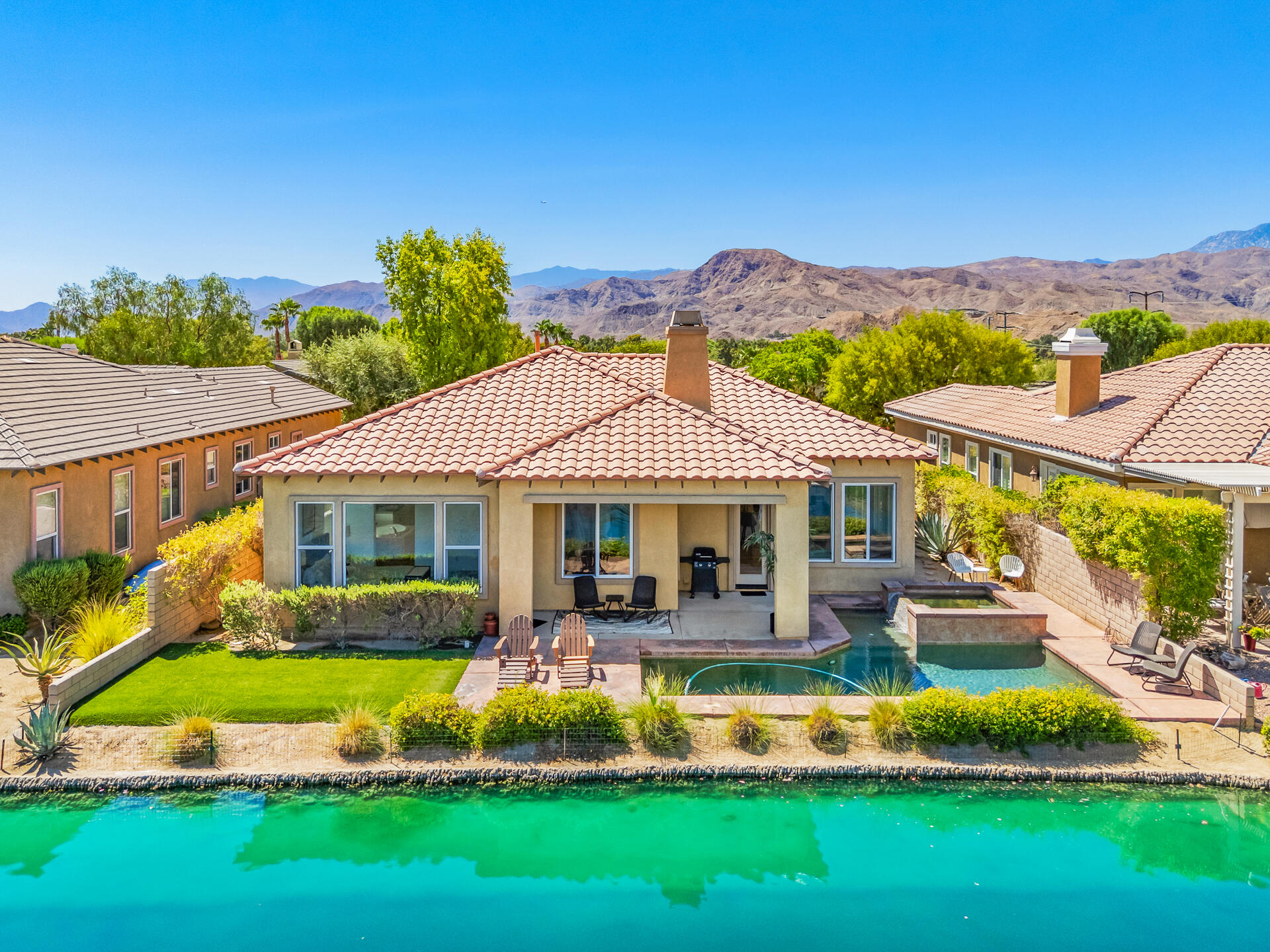 65 Shoreline Drive Rancho Mirage, CA 92270 - Photo 2 of 29 a front view of a house with a yard table and chairs