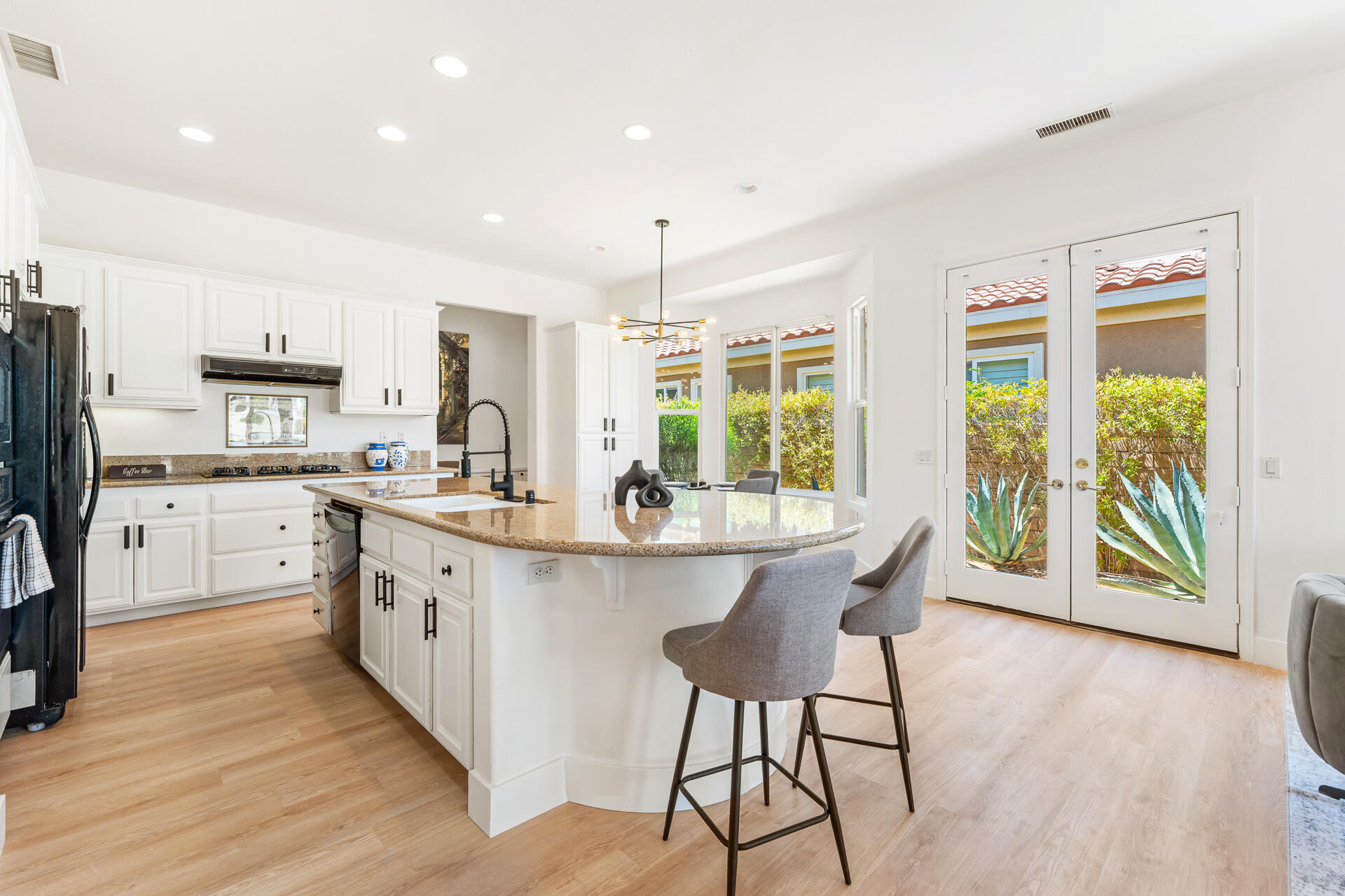 65 Shoreline Drive Rancho Mirage, CA 92270 - Photo 6 of 29 a kitchen with stainless steel appliances granite countertop a stove a sink dishwasher and a refrigerator with wooden floor