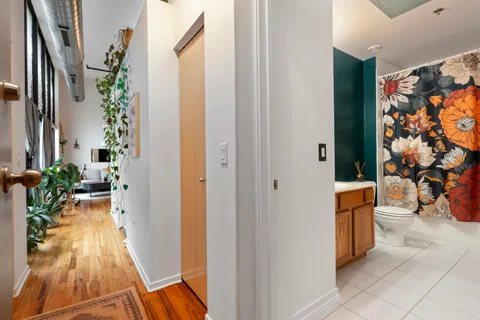 a view of a hallway with wooden floor and a potted plant