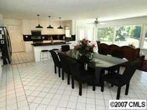 9921 Withers Road Charlotte, NC 28278 - Photo 2 of 8 a kitchen with stainless steel appliances kitchen island granite countertop a table chairs and a refrigerator