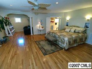 9921 Withers Road Charlotte, NC 28278 - Photo 5 of 8 a spacious bedroom with a bed and a chandelier