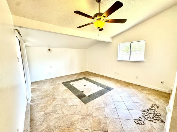 a view of a big room with carpet and a chandelier fan