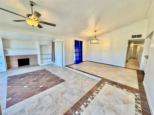 a view of a livingroom with a chandelier fan and wooden floor