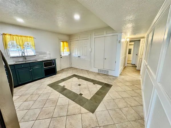 a large white kitchen with a stove a sink dishwasher and cabinets