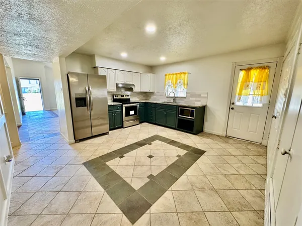 a kitchen with stainless steel appliances granite countertop a refrigerator and a sink